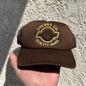 Cherry Co. Quality Goods Trucker Hat (Brown)